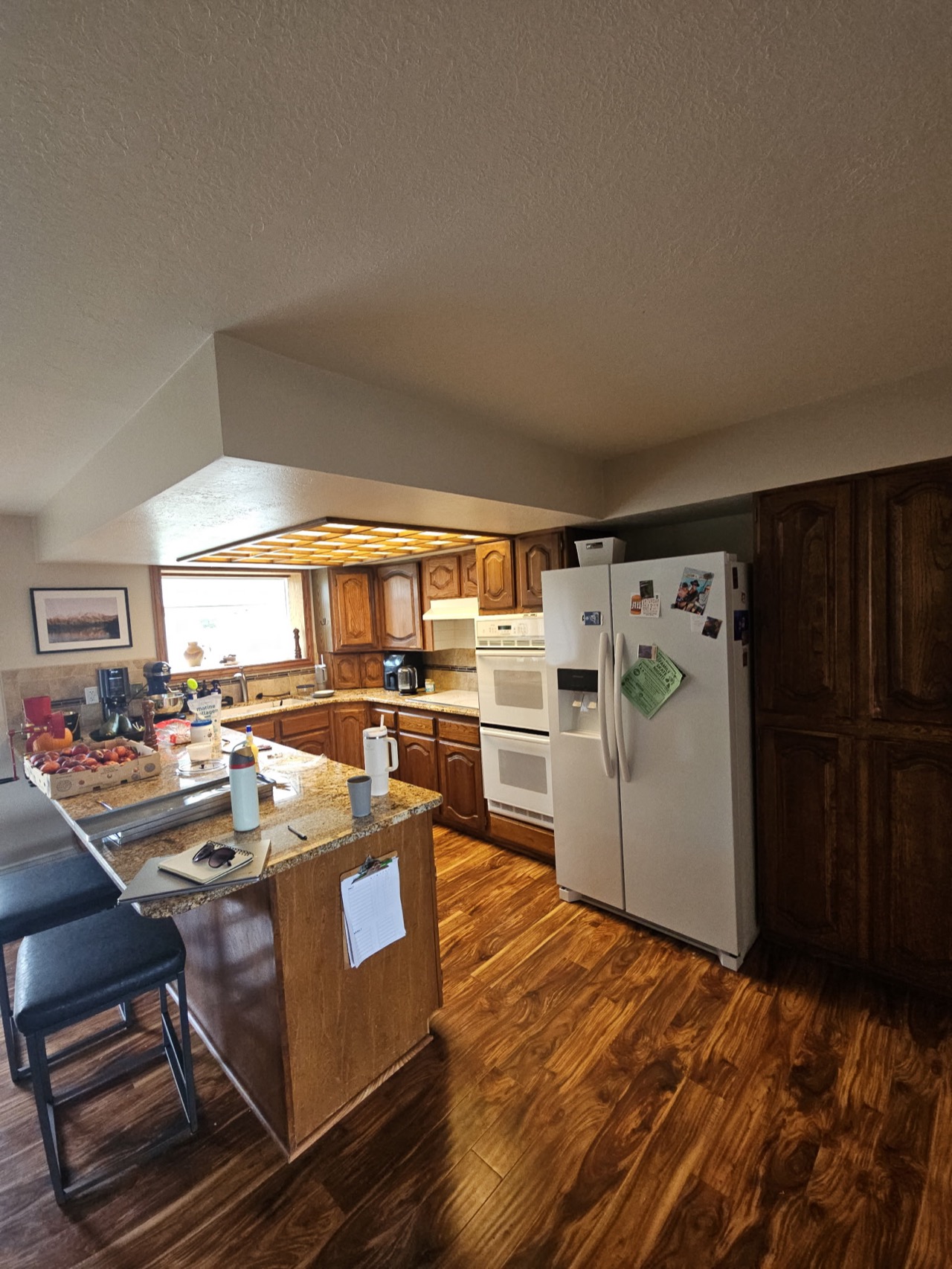 Dated kitchen with dark oak cabinets and fluorescent lighting before renovation