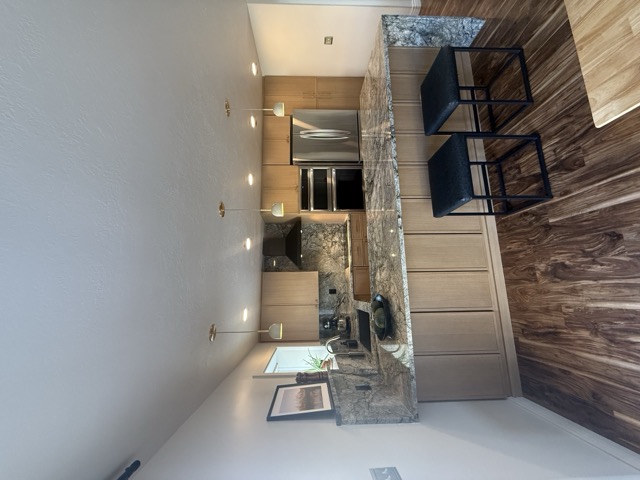 Natural oak cabinets with granite countertop peninsula and bar seating