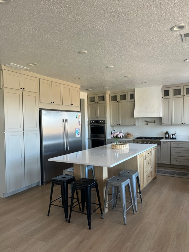 Cream shaker kitchen with quartz island and built-in refrigerator surround